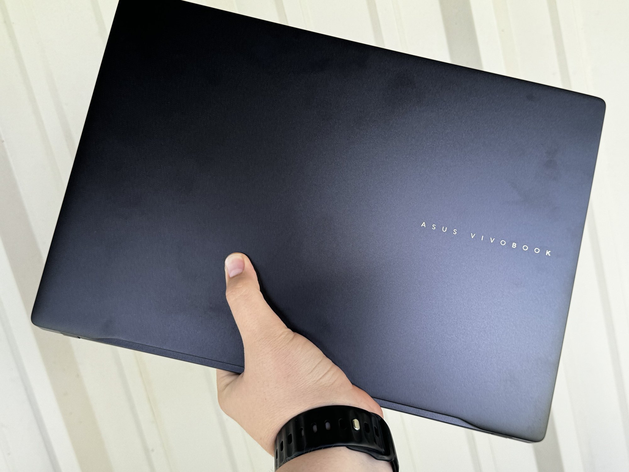 Asus Vivobook S16 OLED laptop held in one hand